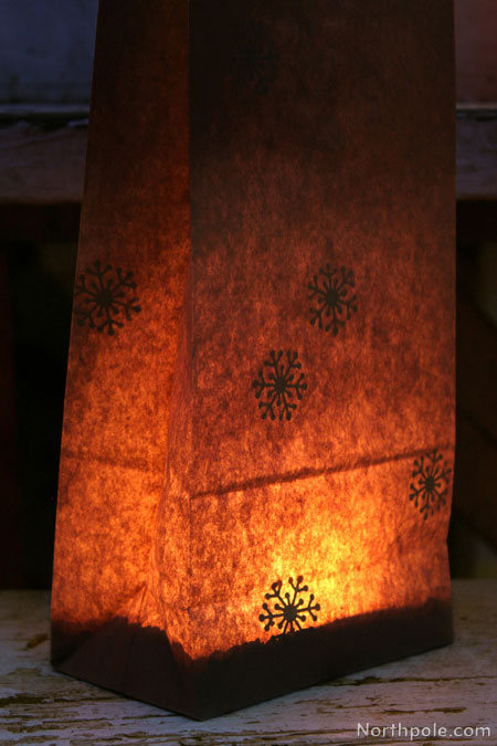 Paper Bag Luminaries: Use a snowflake punch (such as Martha Stewart Crafts Polar punch) to cut out several snowflakes from white printer paper and then glue inside the bag for a silhouette effect.
