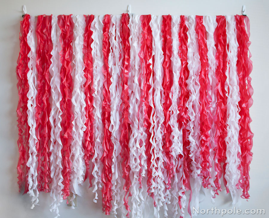 DIY Ruffled Photo Booth Backdrop for Christmas Parties Made from Red and White Plastic Tablecovers